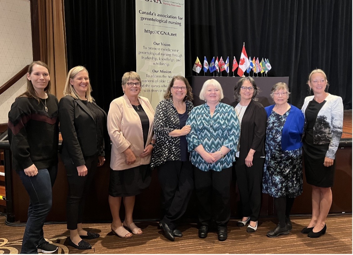 Current and former CGNA presidents pose for a photograph in front of the CGNA banner and provincial flags at the CGNA2023 conference.